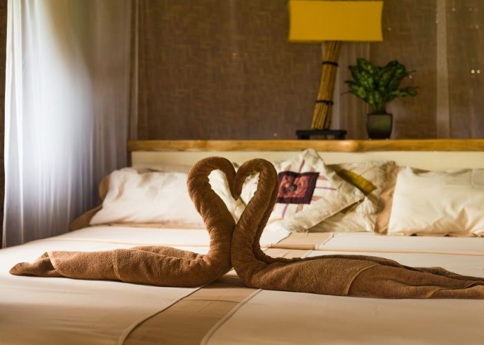 Bed with canopy and swans made of towels in bungalow